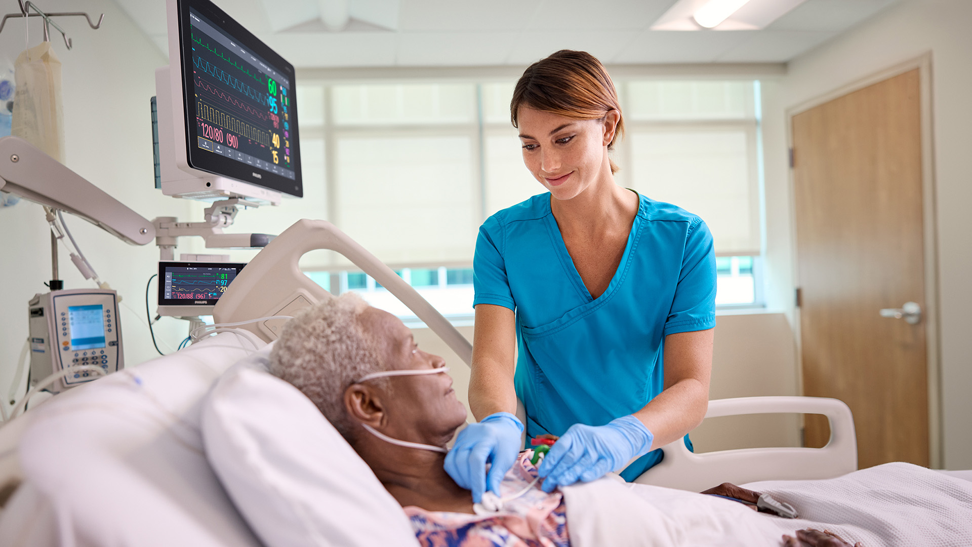 A nurse attending to a patient in a hospital bed
